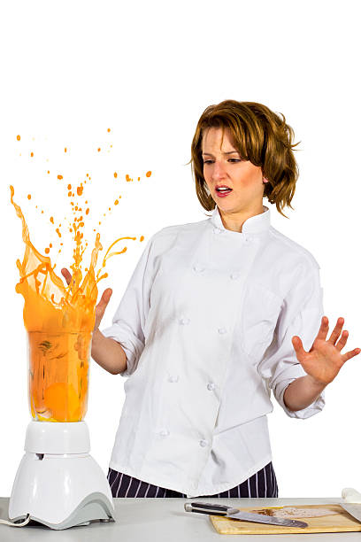 Female Chef Making a Mess with a Blender stock photo