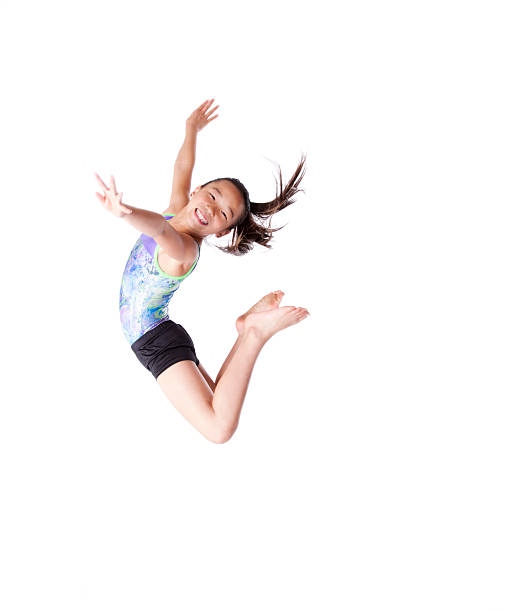Female child gymnast jumping in the air Young, Asian Jumping gymnast against a white background.  Some motion blur visible. chinese girl hairstyle stock pictures, royalty-free photos & images