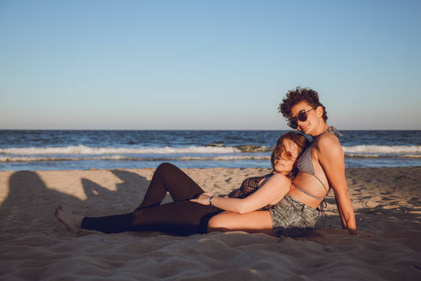 Female couple on the beach Female couple is enjoying beach holiday gay spooning stock pictures, royalty-free photos & images