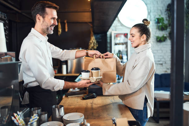 Female customer take away shopping at cafe buying coffee and food stock photo