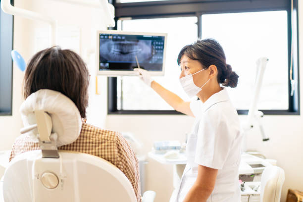 患者にx線について説明する女性歯科医師 - 歯医者 ストックフォトと画像
