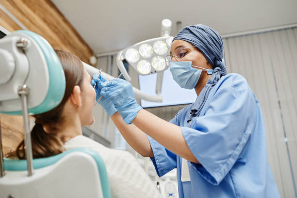 Female Dentist Examining Patient in Clinic stock photo
