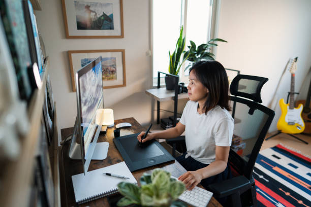 Female designer working from her home office Female designer working from her home office. Okayama, Japan. graphic designer stock pictures, royalty-free photos & images