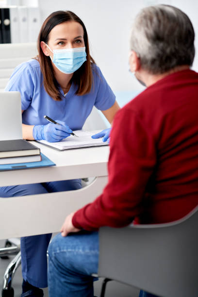 Female doctor conducts a medical interview with the senior patient stock photo
