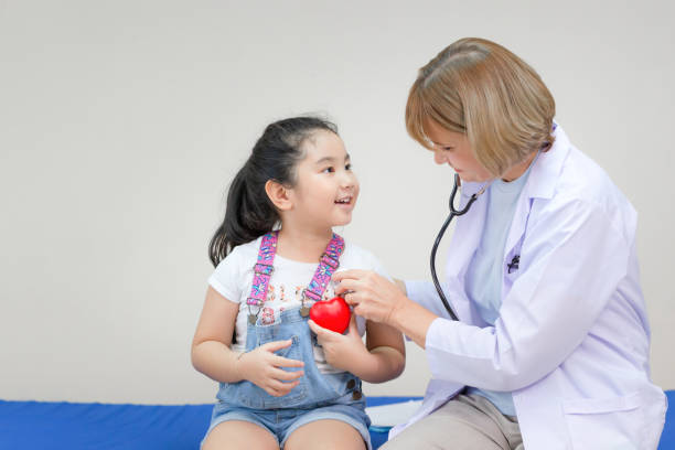 Female doctor examining a little cute girl by stethoscope, Kid on consultation at the pediatrician. Healthcare and medicine concepts stock photo
