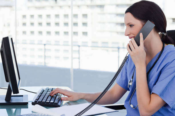 kvinnliga läkare på telefonen medan du använder en bildskärm - happy scrubs nurse phone bildbanksfoton och bilder