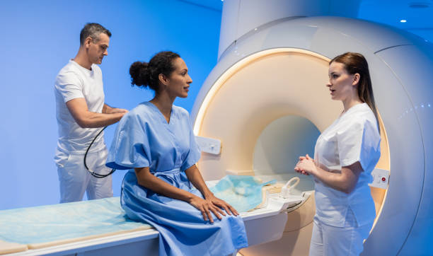 Female Doctor Preparing Patient For MRI Scan stock photo