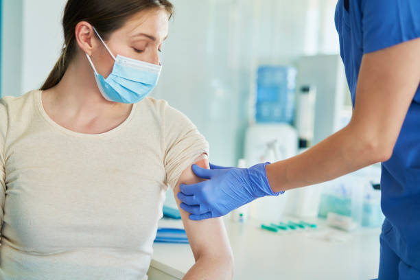 Female doctor puts the patch on the patient's arm stock photo