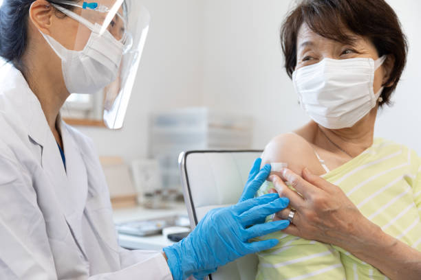 Female doctor putting adhesive plaster after vaccine shot stock photo