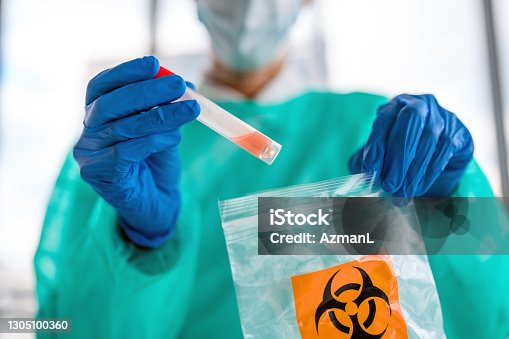 istock Female Doctor Putting  Sample of COVID-19 Test in Biohazard Bag 1305100360