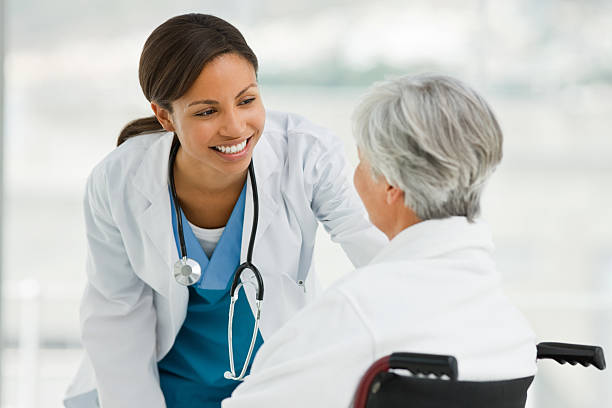 Female doctor talking with senior patient stock photo