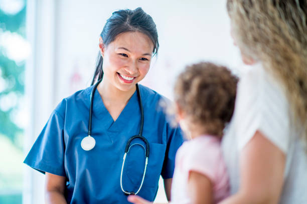 Female doctor with a young girl patient and her mother Female doctor with a stethoscope and scrubs in a medical office with a young girl patient and the mother general practitioner photos stock pictures, royalty-free photos & images