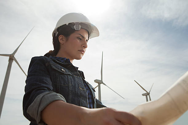 Female engineer at wind farm with plans  wind power stock pictures, royalty-free photos & images