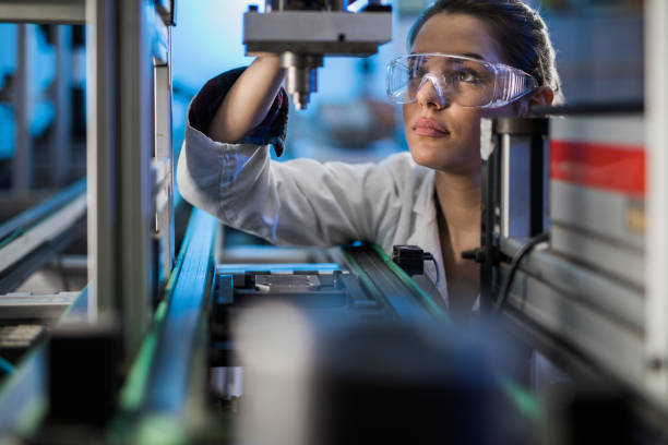 vrouwelijke ingenieur machine deel op een productielijn te onderzoeken. - high tech lab stockfoto's en -beelden