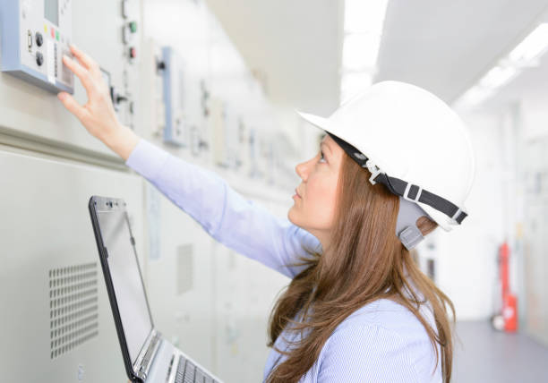 Female engineer is checking equipment in power substation Woman standing in front of the control panel in the control room energy efficient stock pictures, royalty-free photos & images