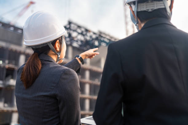 Female engineers working together at construction site stock photo
