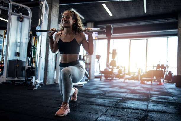 Female exercising with weights in the gym. Bodybuilding and training in fitness center. Female exercising with weights in the gym. Bodybuilding and training in fitness center. bodybuilder stock pictures, royalty-free photos & images