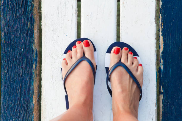 Female feet on jetty Female feet with flip flops on the jetty. Top view flip flop stock pictures, royalty-free photos & images