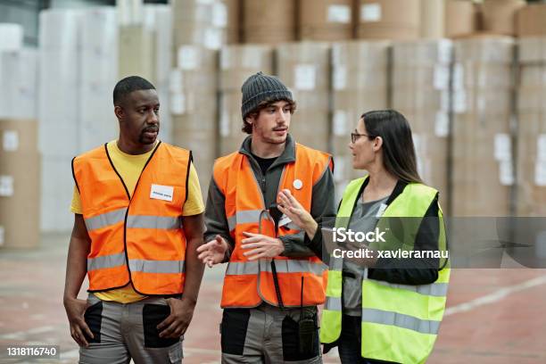 Female foreperson Making Plans with Warehousemen