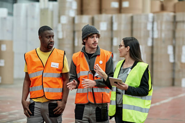 Female foreperson Making Plans with Warehousemen stock photo
