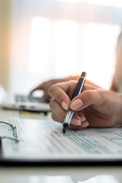 female hand filling us tax form, 1040 stock photo