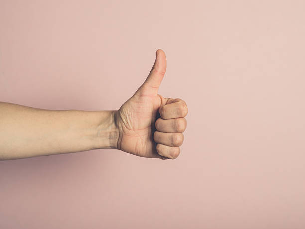 Female hand giving thumbs up stock photo
