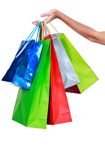 Female hand holding group of shopping bags. Christmas shopping themes.