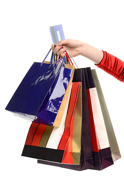 Female hand holding many shopping bags and a credit card. stock photo