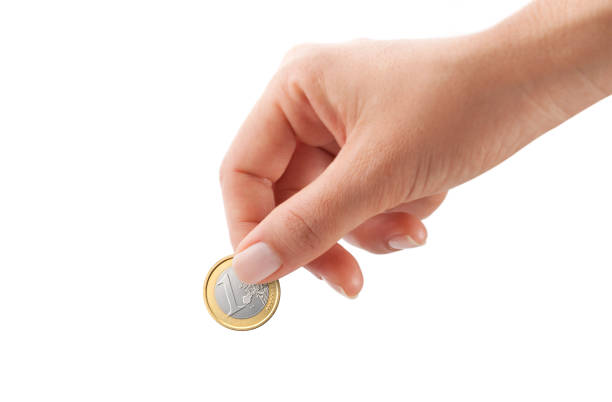Female hand holding one euro coin stock photo