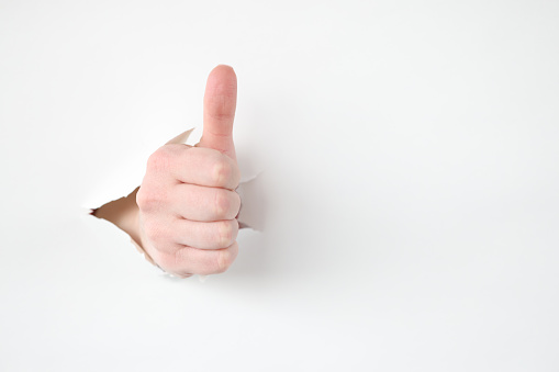 Female hand makes thumbs up gesture. Business success and career building concept