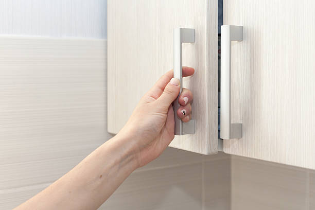 Female hand open the cupboard doors, close up Female hand open the cupboard doors, close up knob stock pictures, royalty-free photos & images
