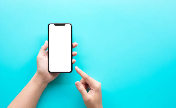 mano femenina usando el teléfono inteligente con la pantalla en blanco en el fondo del color - mano humana fotografías e imágenes de stock