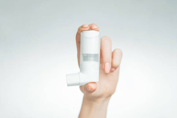 Female hand with a medical asthma inhaler. stock photo