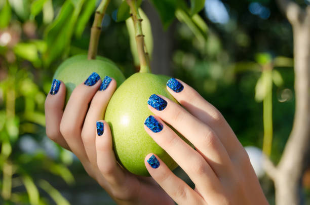 Female hand with blue nail art stickers stock photo