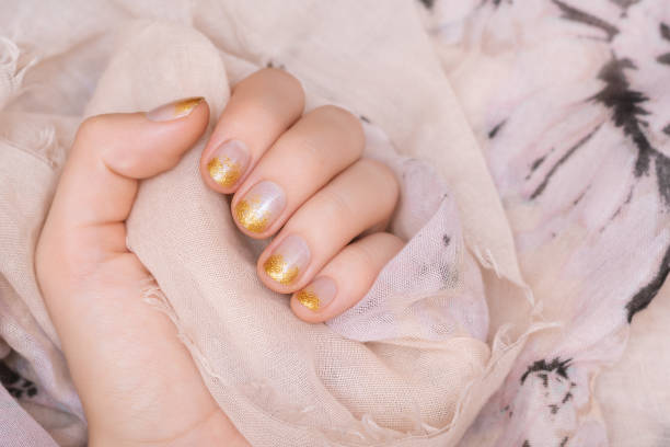 Female hand with gold glitter nail design. stock photo