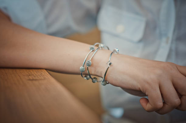 Female hand with three silver bracelets stock photo