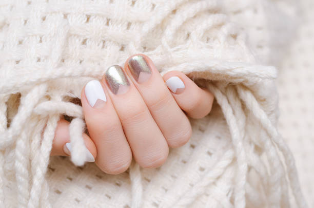 Female hand with white and silwer nail design stock photo