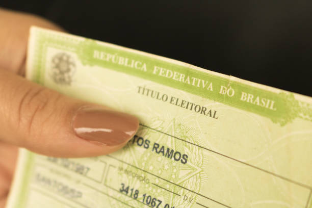 Female hands holding brazilian elector's title voter. (translation: "Federative Republic of Brazil, voter title). stock photo