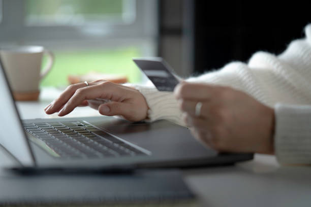 Female hands holding credit card and using laptop. Online shopping stock photo