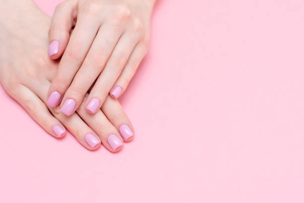 Female hands manicure close up view on pink knitted sweater background. Nail painting effects. Manicure salon banner concept Female hands manicure close up view on pink knitted sweater background. Nail painting effects. Manicure salon banner concept. painting fingernails stock pictures, royalty-free photos & images