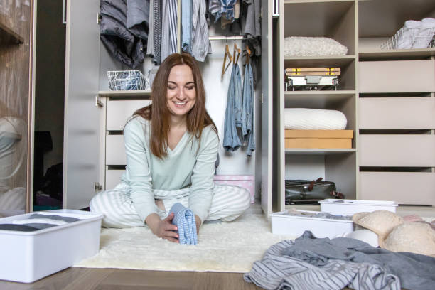 Female hands organizing storage of underwear socks t shirts use Marie Kondo's method. Perfectionist stock photo