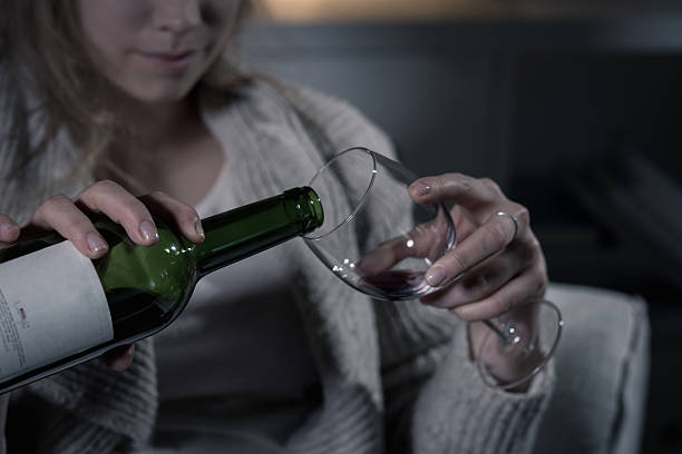 Female hands pouring red wine Close-up of female hands pouring red wine alcohol abuse stock pictures, royalty-free photos & images