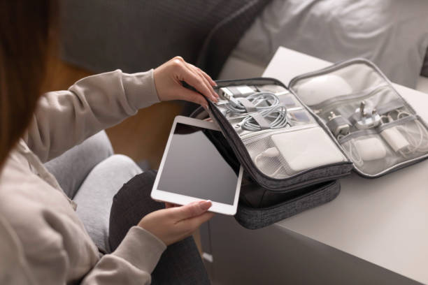Female hands putting tablet pc into comfortable bag storage get ready to business trip or vacation stock photo