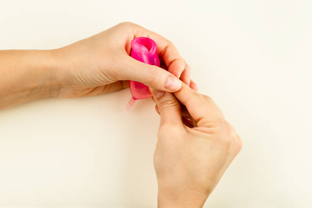 Female hands showing how to use a Menstrual Cup stock photo