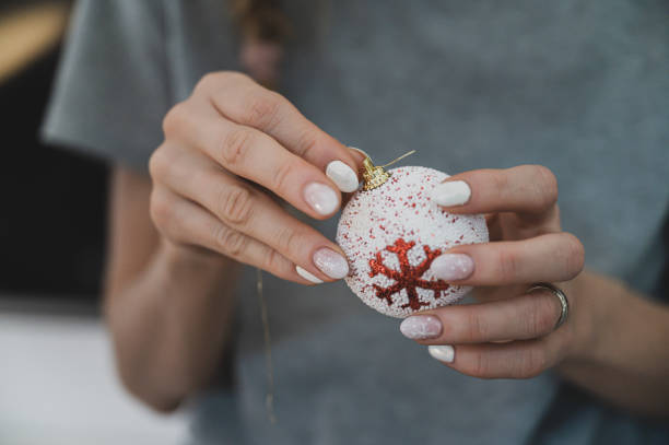 Female hands with winter manicure holding christmas bauble stock photo