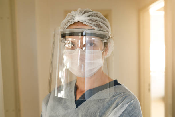 Female health care worker using face shield Female health care worker. nurse face stock pictures, royalty-free photos & images