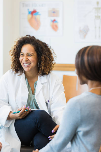 Female healthcare workers smile at unseen person in meeting stock photo