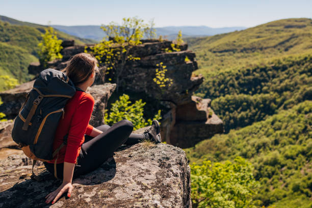 Female hiker, admiring the view from the top of the mountain, during her summer adventure stock photo