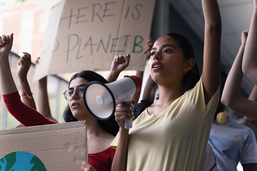 Female hispanic latin teenager students with placards and posters on global protest for climate change and Earth rights