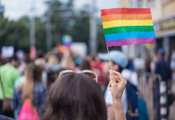 vrouw houdt van kleurrijke vlag op straat maart - gay demonstration stockfoto's en -beelden